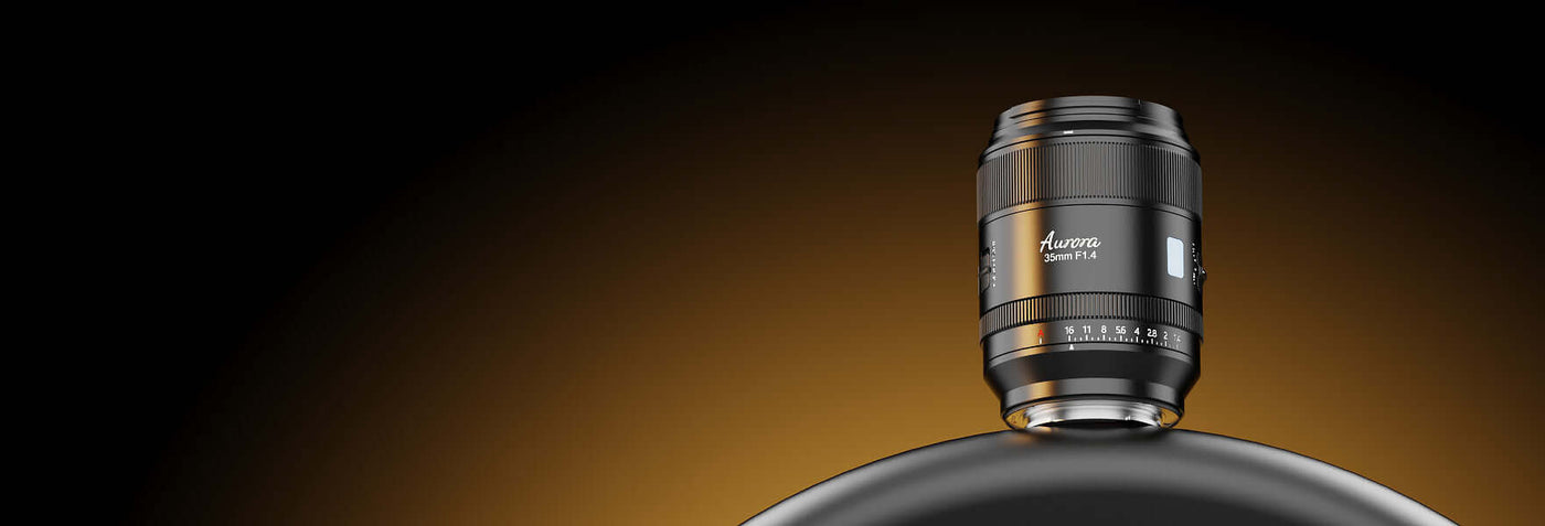 Close-up of a modern camera lens on a sleek black surface with an orange gradient background.