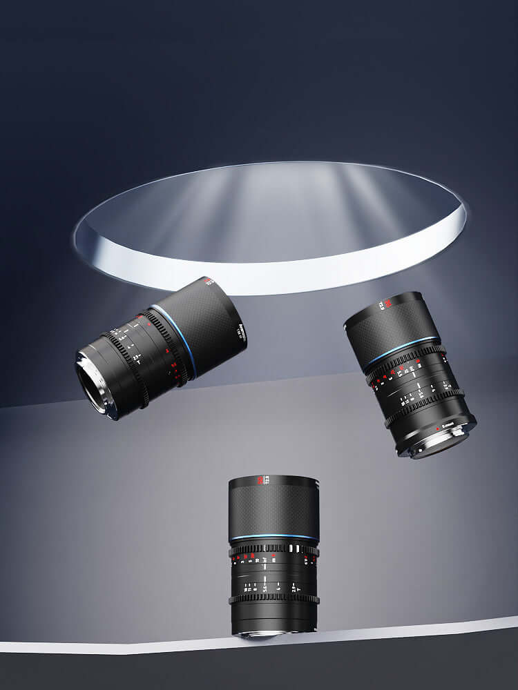 Three camera lenses displayed elegantly under a spotlight, showcasing their sleek black design and detailed focus rings.