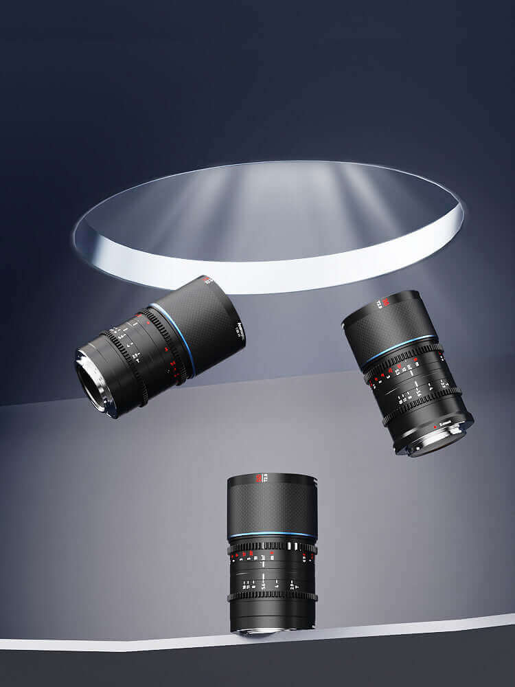 Three camera lenses displayed elegantly under a spotlight, showcasing their sleek black design and detailed focus rings.