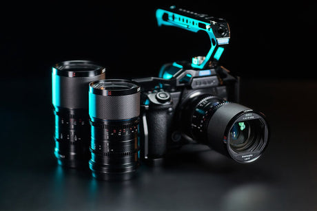 Professional camera setup with two lenses and a camera body, illuminated with blue highlights.