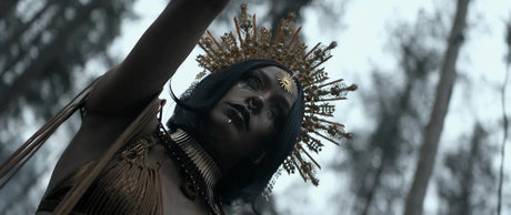 Dutch angle shot of a woman in a golden headdress filmed from a low, tilted camera angle
