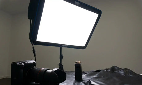 Self-inflating flat light setup for photography with a camera and lighting equipment on a table.