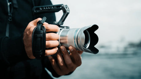 Hands holding an APS-C camera with the SIRUI Sniper F1.2 autofocus lens