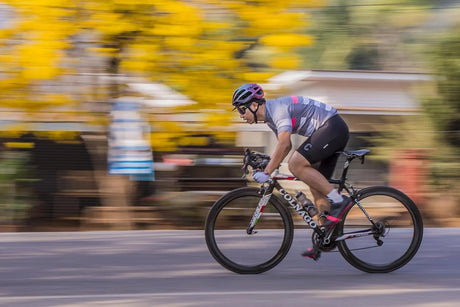 Panning shot of a road cyclist in sharp focus with a motion-blurred background