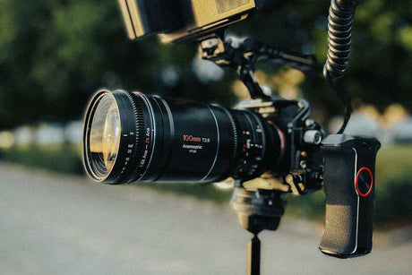 Close-up of a camera with a 100mm T2.9 lens, showcasing videography equipment for high-quality filming.