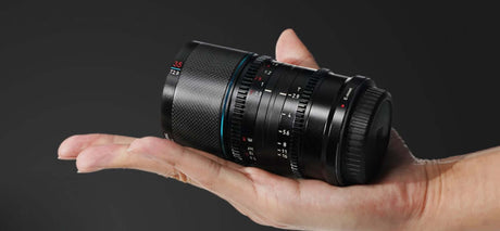 SIRUI Saturn 35mm Full-frame Carbon Fiber Anamorphic Lens held in hand on a dark background.