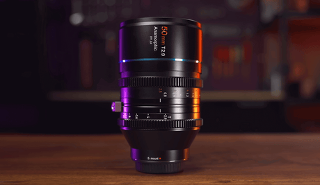 SIRUI 50mm T2.9 full frame anamorphic lens on a wooden surface with vibrant lighting.