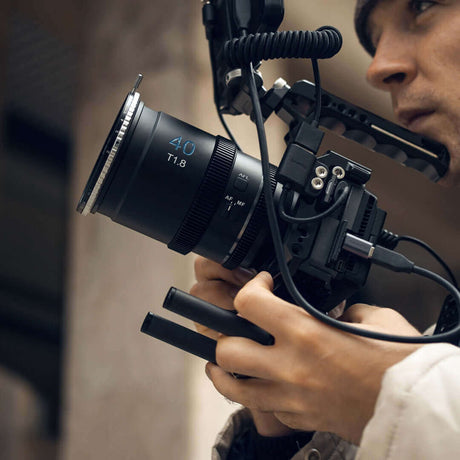 Close-up of a filmmaker holding a camera rig with 40mm T1.8 lens, showcasing a cinematic shooting setup.