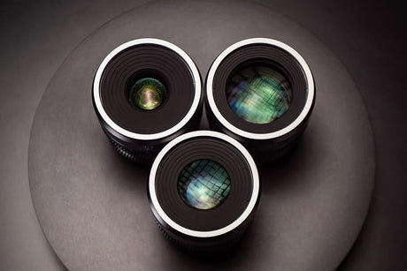 Three four thirds camera lenses displayed on a circular surface, highlighting their optical designs and features.