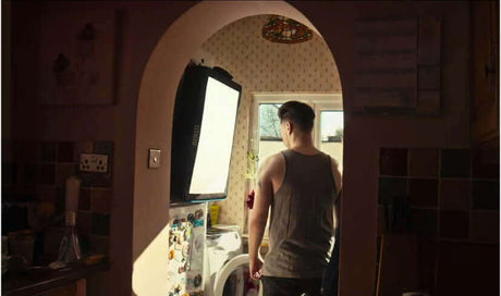 A person standing in a kitchen illuminated by a self-inflating flat light source.