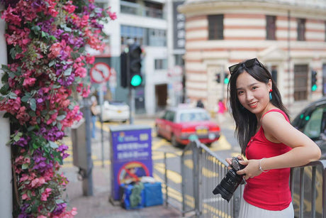 Behind the Scenes: What Camera is Used to Film Outer Banks? A woman holding a camera in a colorful urban setting.