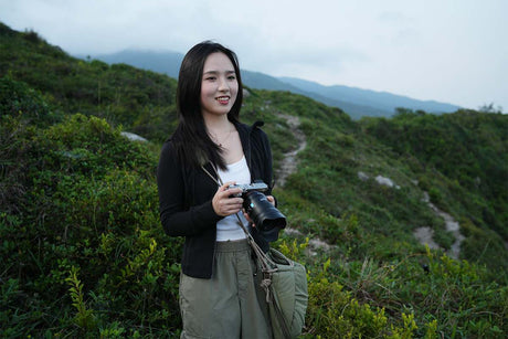 Ultimate Guide to Capturing a Photo with Background Blurred Effect: photographer smiling outdoors with a camera