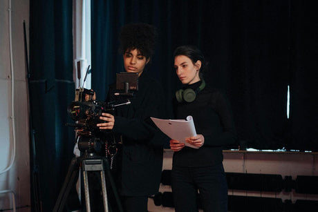 Two women collaborating on a photography setup, learning how to photograph products like a professional photographer.