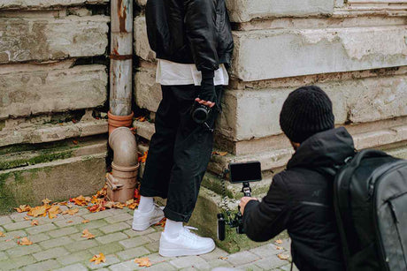 Creative Ground Low-angle Shots Ideas to Try - photographer capturing a model near a wall with leaves on the ground.