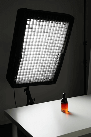 SIRUI A100B bi-color self-inflating LED light illuminating a bottle on a table.