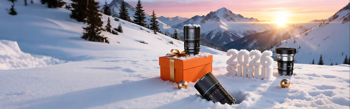 Snowy mountain landscape featuring camera lenses, a gift box, and the year 2026 with a sunset backdrop.